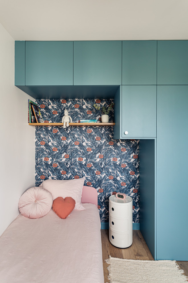 Bild på ett mellanstort minimalistiskt könsneutralt tonårsrum, med blå väggar och ljust trägolv