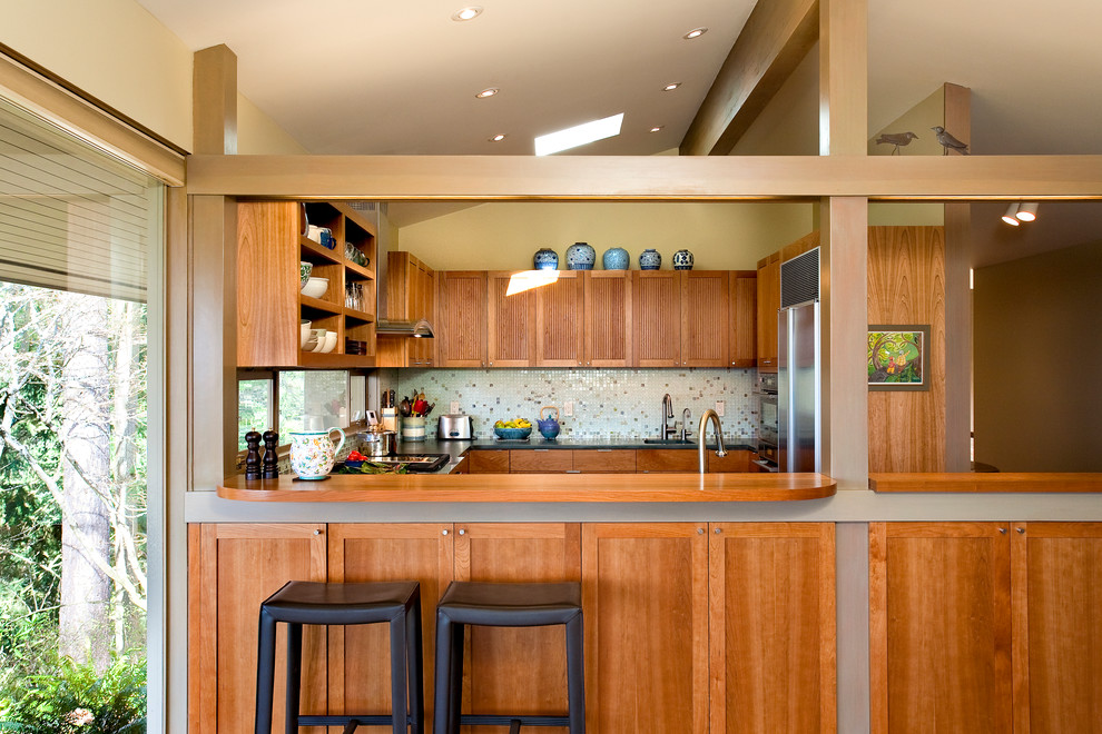 Design ideas for a midcentury u-shaped separate kitchen in Seattle with recessed-panel cabinets, medium wood cabinets, wood benchtops, mosaic tile splashback, stainless steel appliances and multi-coloured splashback.