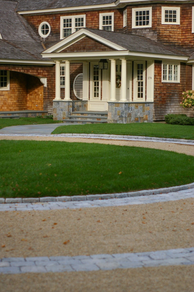 Photo of a large beach style front yard full sun driveway in Boston with gravel.