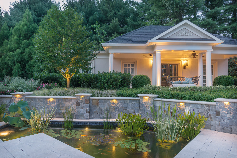 Expansive traditional backyard full sun formal garden in DC Metro with a water feature and natural stone pavers for spring.
