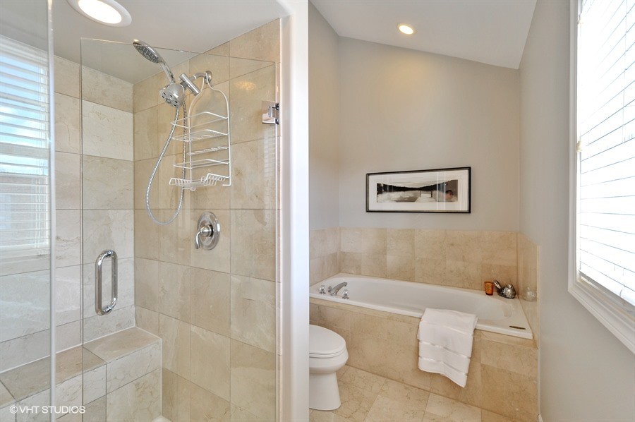 Transitional master bathroom in Chicago with flat-panel cabinets, light wood cabinets, an alcove tub, an alcove shower, a two-piece toilet, beige tile, stone tile, grey walls, travertine floors, an undermount sink and granite benchtops.