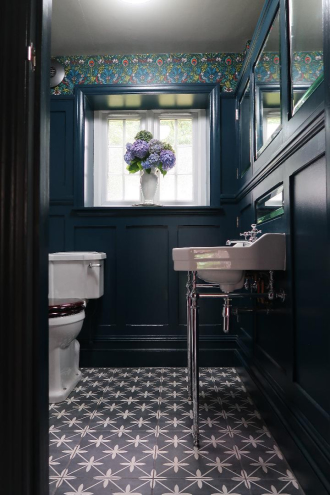 Inspiration for a mid-sized traditional 3/4 bathroom in Sussex with shaker cabinets, blue cabinets, an open shower, ceramic tile, a single vanity, a freestanding vanity, a two-piece toilet, white tile, blue walls, porcelain floors, a wall-mount sink, grey floor, an open shower and panelled walls.