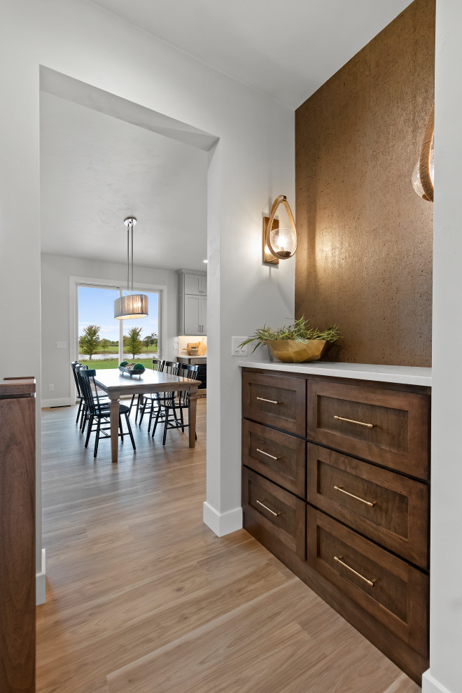 Example of a mid-sized transitional vinyl floor, brown floor and wallpaper hallway design with white walls