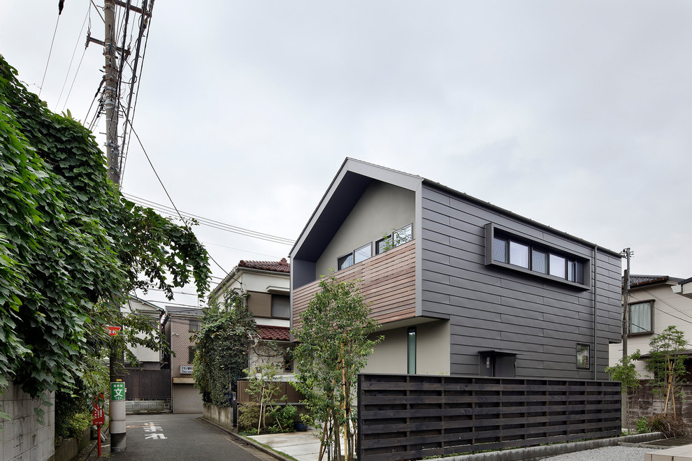 This is an example of a small scandinavian three-storey multi-coloured house exterior in Tokyo with a gable roof and a metal roof.