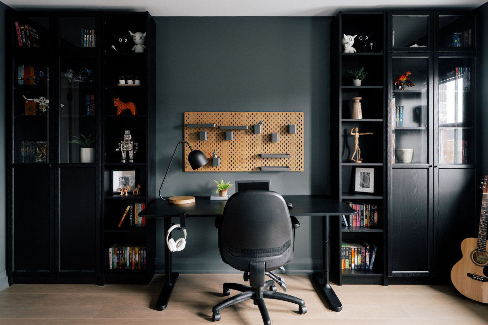 Ispirazione per un ufficio design di medie dimensioni con pavimento in legno massello medio, scrivania autoportante, pavimento marrone e pareti verdi
