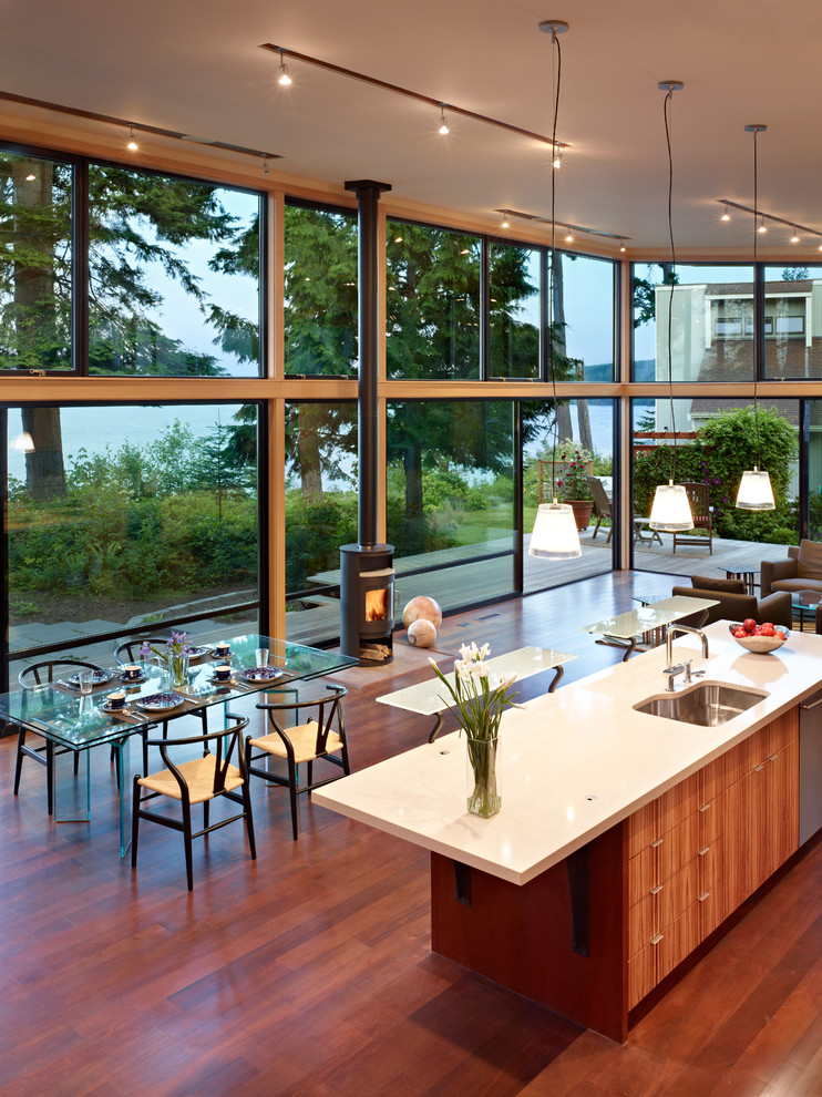 Modern open plan kitchen in Seattle with a single-bowl sink, flat-panel cabinets, medium wood cabinets, stainless steel appliances and quartz benchtops.