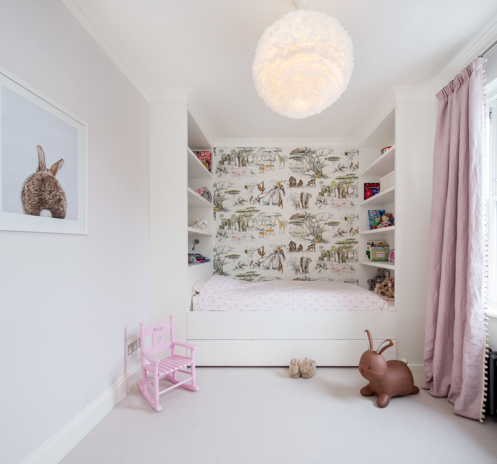 Photo of a mid-sized transitional kids' bedroom for kids 4-10 years old and girls in London with carpet, beige floor and multi-coloured walls.