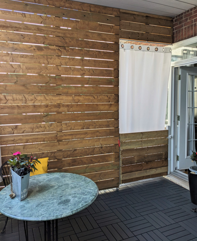 Idee per un privacy sul balcone contemporaneo di medie dimensioni con un tetto a sbalzo e parapetto in legno