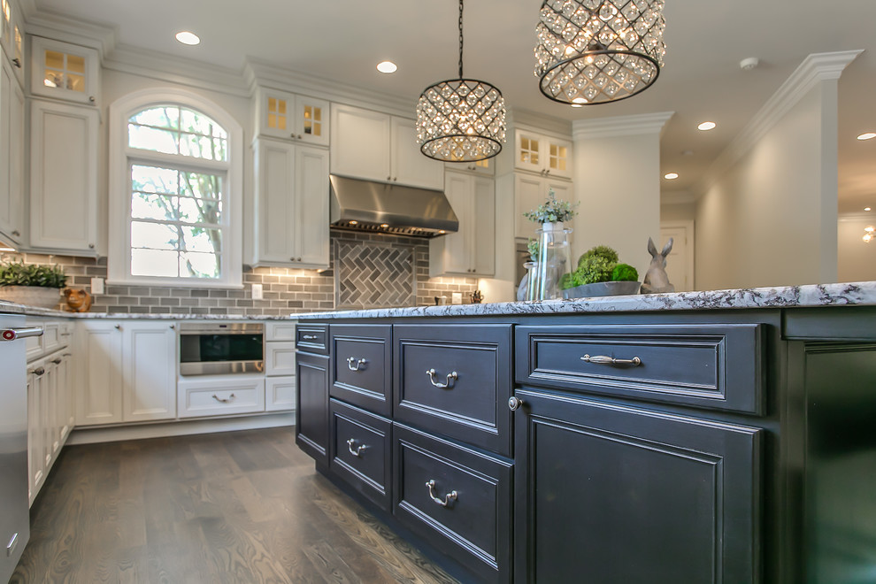 Design ideas for a large traditional eat-in kitchen in Nashville with flat-panel cabinets, white cabinets, granite benchtops, grey splashback, glass tile splashback, stainless steel appliances, dark hardwood floors, with island, brown floor and multi-coloured benchtop.