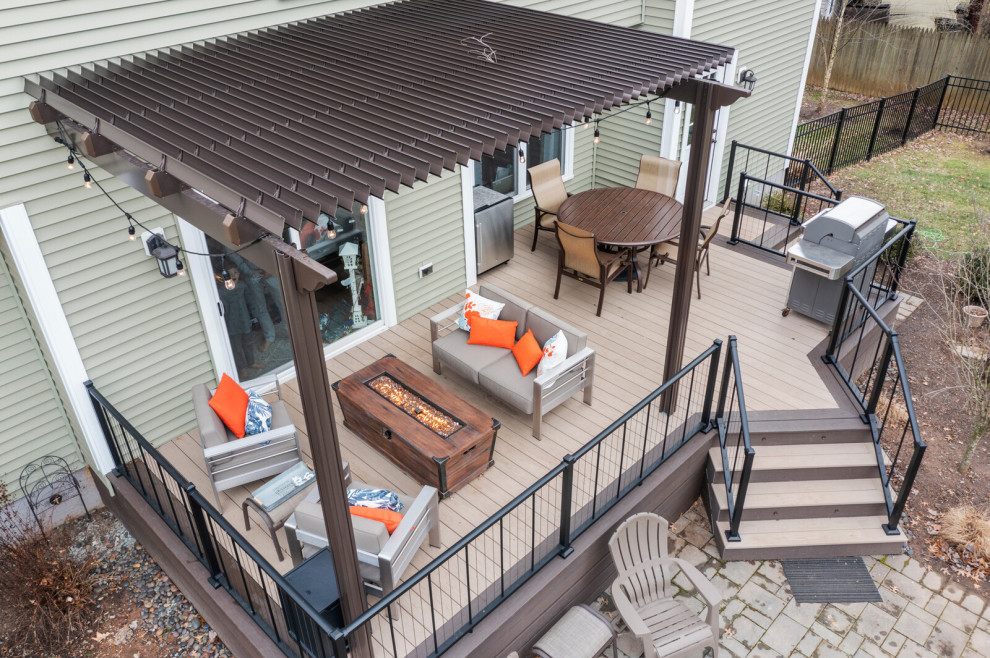 Ejemplo de terraza planta baja clásica pequeña en patio trasero con brasero, pérgola y barandilla de metal
