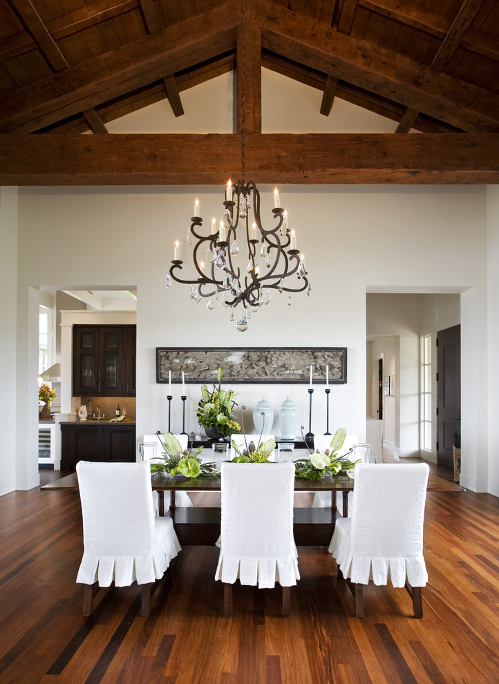 Inspiration for a tropical dining room in San Francisco with white walls and dark hardwood floors.