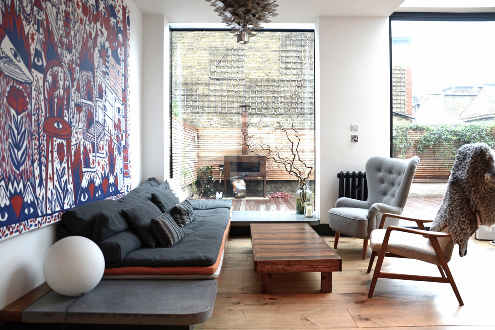 Photo of a mid-sized contemporary living room in London with white walls, light hardwood floors and beige floor.