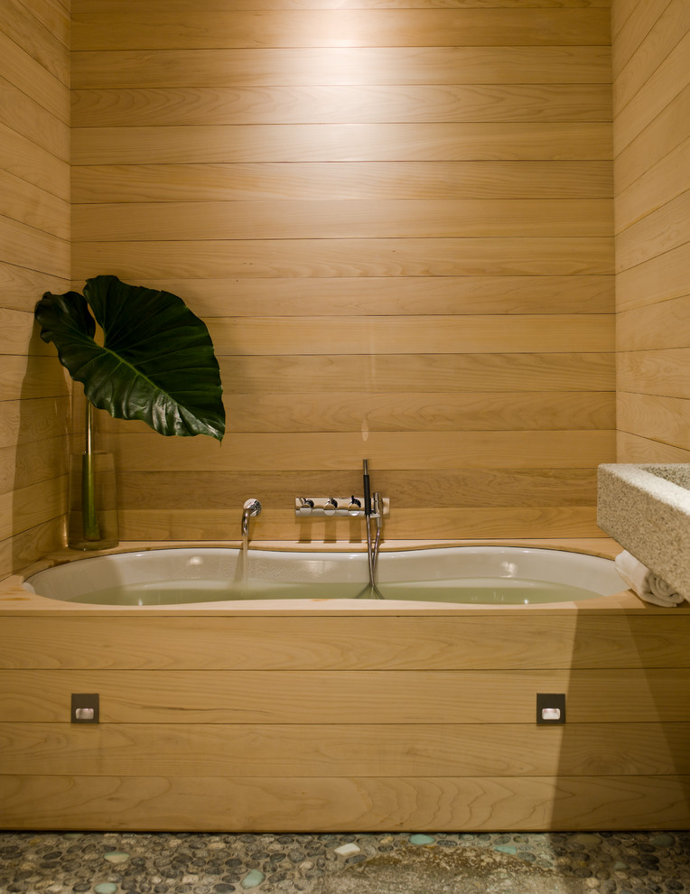 Inspiration for a mid-sized asian master wet room bathroom in Portland with open cabinets, light wood cabinets, a japanese tub, a one-piece toilet, multi-coloured walls, pebble tile floors, a trough sink, granite benchtops, multi-coloured floor, an open shower and multi-coloured benchtops.