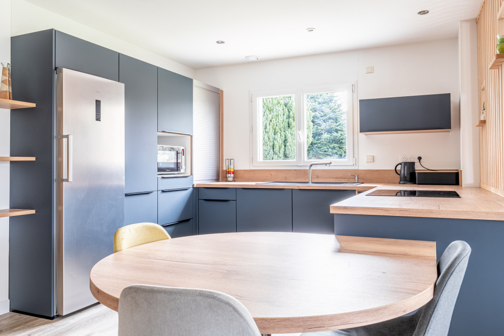 Medium sized contemporary u-shaped open plan kitchen in Nantes with blue cabinets, laminate countertops and an island.