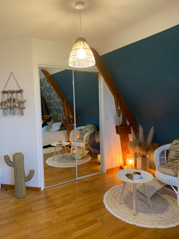 Ispirazione per una camera da letto stile loft tropicale di medie dimensioni con pareti blu, parquet chiaro, nessun camino, pavimento marrone, travi a vista e carta da parati