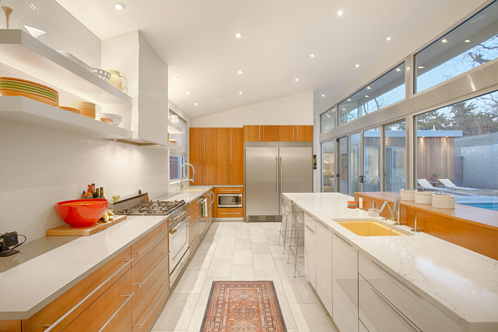 Design ideas for a large midcentury galley open plan kitchen in Oklahoma City with an undermount sink, flat-panel cabinets, medium wood cabinets, quartz benchtops, white splashback, mosaic tile splashback, stainless steel appliances, porcelain floors and white floor.
