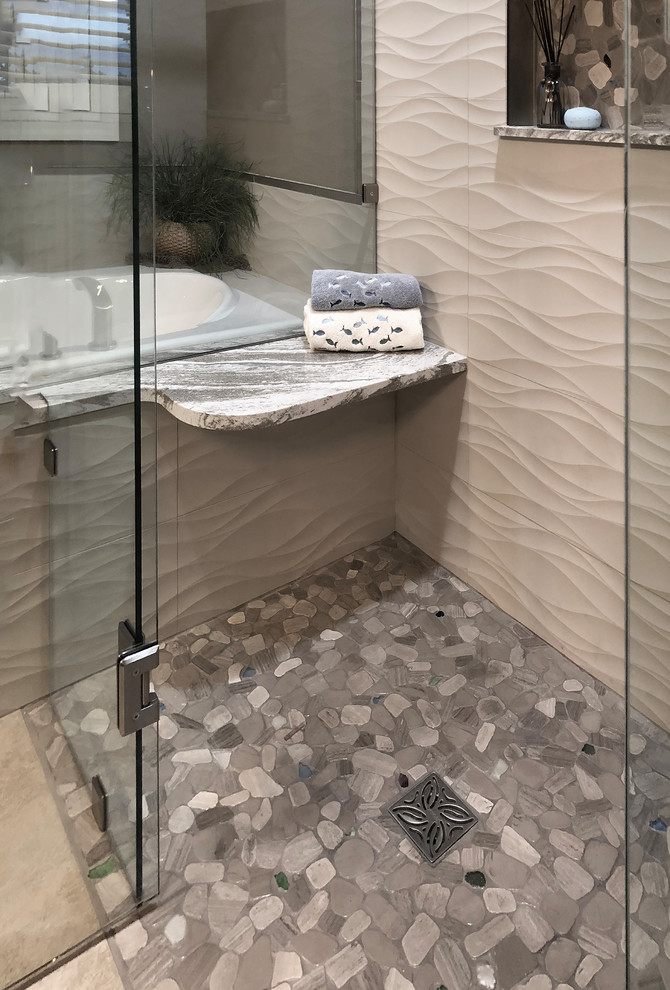 Photo of a mid-sized beach style master bathroom in Seattle with shaker cabinets, white cabinets, an alcove tub, a curbless shower, a two-piece toilet, beige tile, porcelain tile, black walls, porcelain floors, an undermount sink, engineered quartz benchtops, beige floor, a hinged shower door and black benchtops.