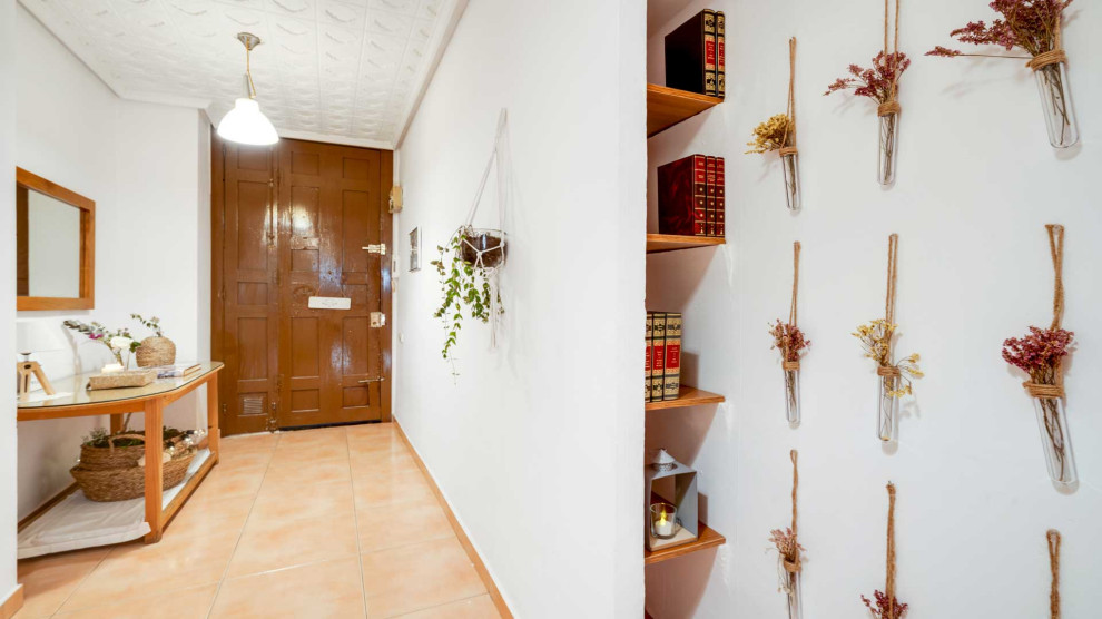 Photo of a large transitional hallway in Other with white walls and beige floor.