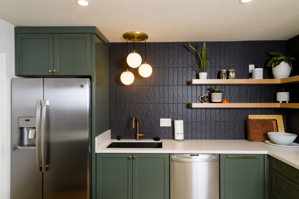 Bild på ett litet nordiskt vit vitt l-kök, med en undermonterad diskho, skåp i shakerstil, gröna skåp, bänkskiva i kvarts, svart stänkskydd, stänkskydd i tunnelbanekakel, rostfria vitvaror, ljust trägolv, en köksö och brunt golv