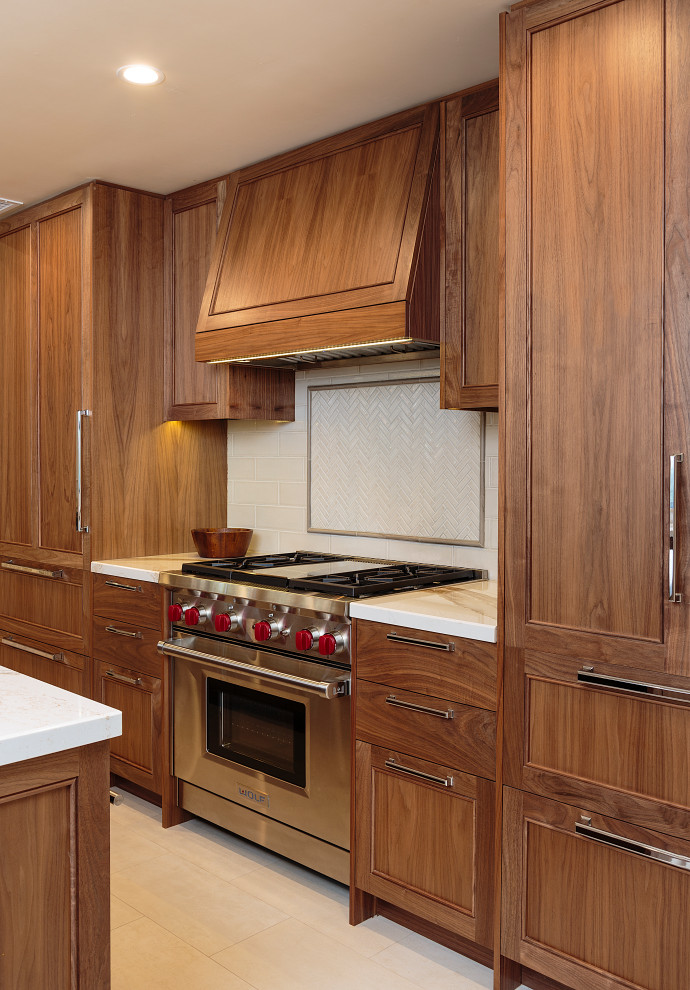 Example of a mid-sized transitional beige floor and limestone floor open concept kitchen design in Los Angeles with an undermount sink, recessed-panel cabinets, medium tone wood cabinets, quartz countertops, white backsplash, ceramic backsplash, stainless steel appliances, an island and white countertops