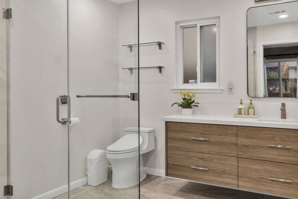 Example of a small mid-century modern 3/4 gray tile and ceramic tile ceramic tile, gray floor, double-sink and brick wall alcove shower design in Seattle with flat-panel cabinets, brown cabinets, a two-piece toilet, gray walls, an undermount sink, quartz countertops, a hinged shower door, white countertops and a floating vanity