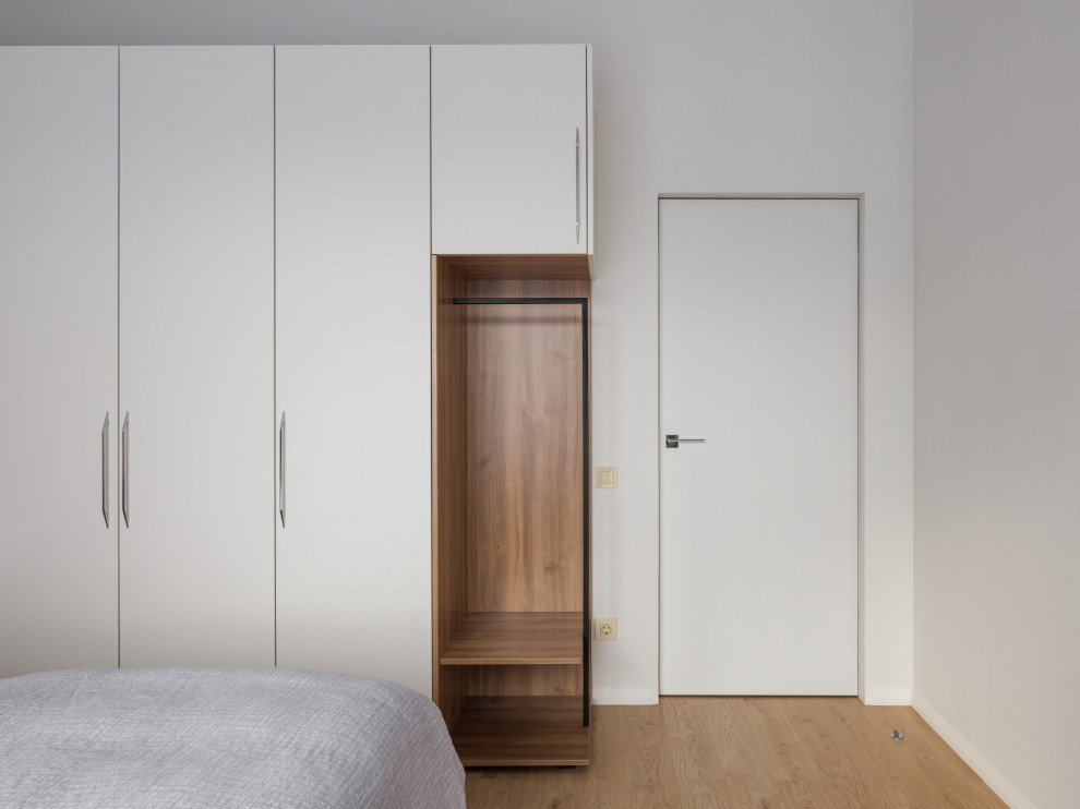 Идея дизайна: хозяйская спальня среднего размера, в светлых тонах, в белых тонах с отделкой деревом в современном стиле с белыми стенами, полом из ламината и бежевым полом