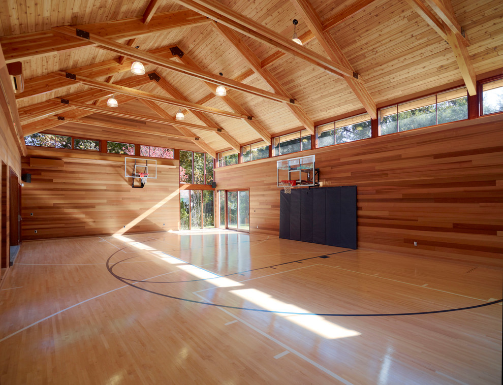This is an example of a large contemporary indoor sport court in Boston with brown walls, light hardwood floors and brown floor.