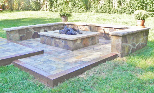 Design ideas for a large country backyard patio in Kansas City with a fire feature, natural stone pavers and no cover.