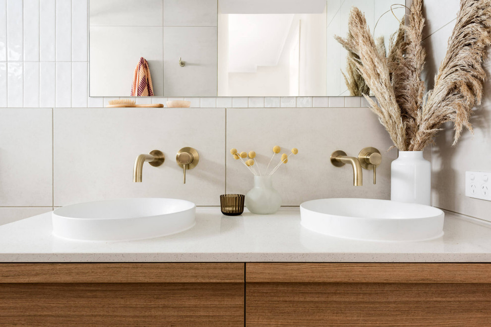 Example of a mid-sized minimalist kids' white tile and stone tile ceramic tile, white floor and double-sink bathroom design in Melbourne with flat-panel cabinets, dark wood cabinets, a wall-mount toilet, white walls, a vessel sink, quartz countertops, a hinged shower door, white countertops and a floating vanity