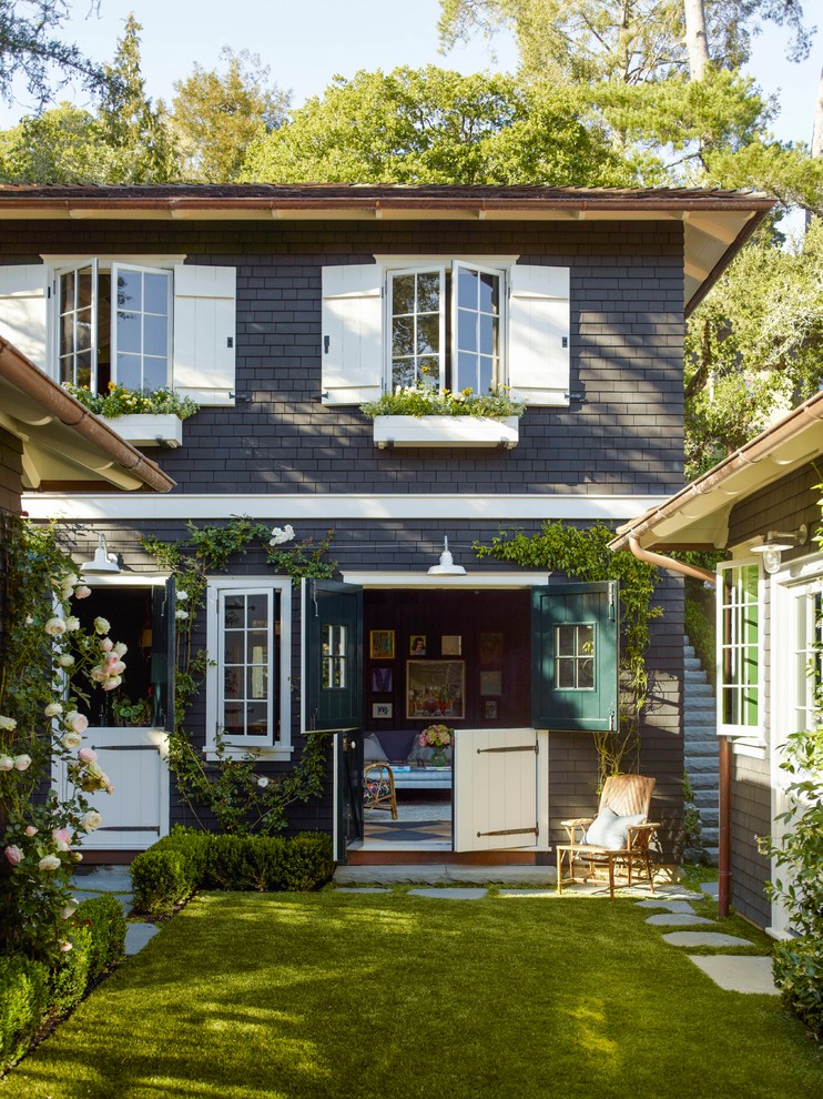 Стильный дизайн: двухэтажный, синий частный загородный дом в классическом стиле с коричневой крышей и отделкой дранкой - последний тренд