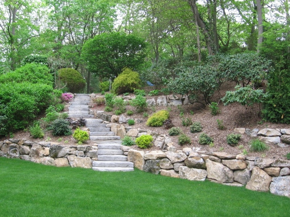 This is an example of a large traditional backyard partial sun garden for summer in New York with natural stone pavers and a vertical garden.