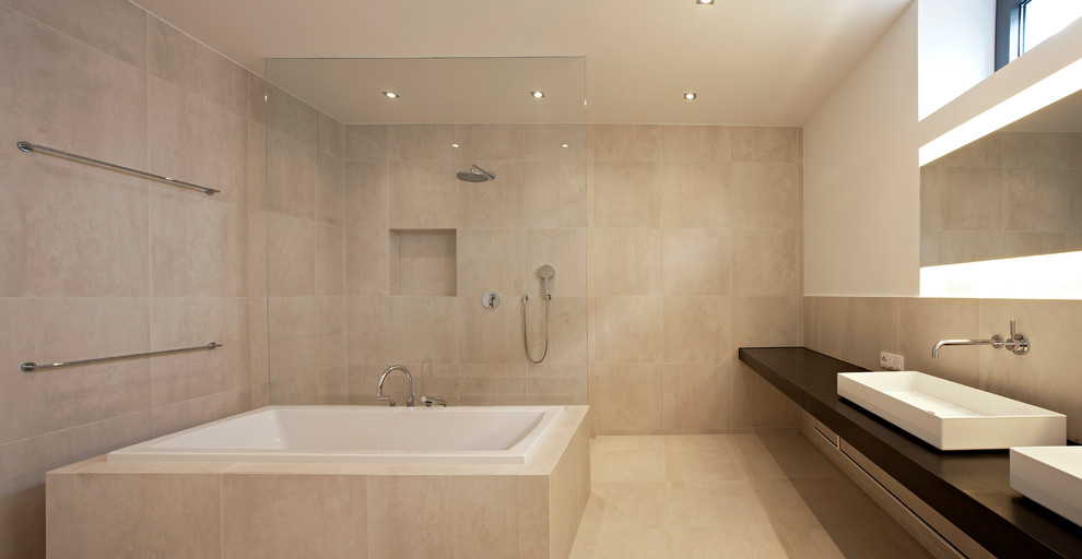 Mid-sized modern master bathroom in Dusseldorf with a drop-in tub, an open shower, beige tile, beige walls and a vessel sink.