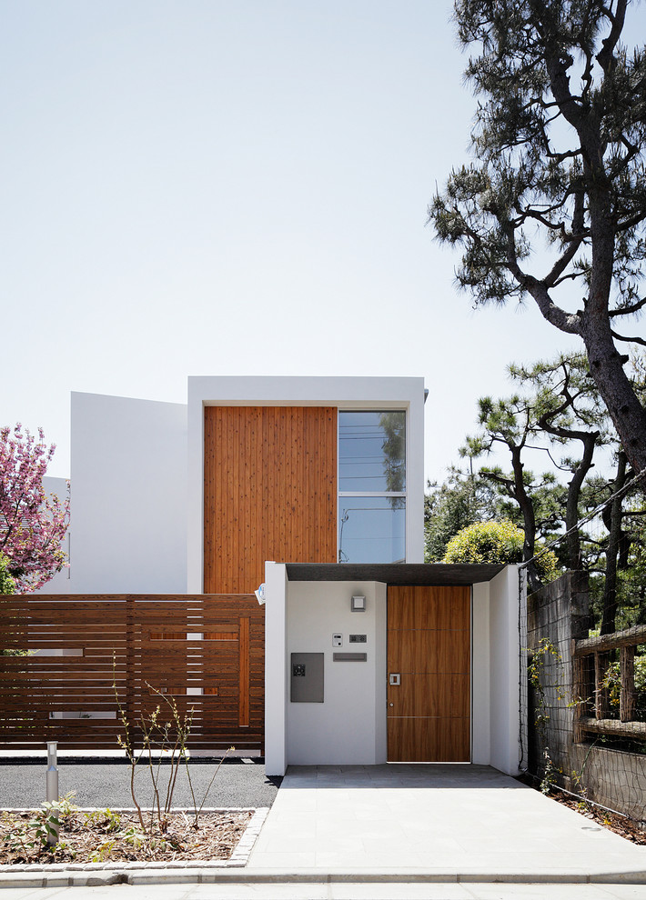 Design ideas for a contemporary two-storey white exterior in Tokyo with a flat roof.