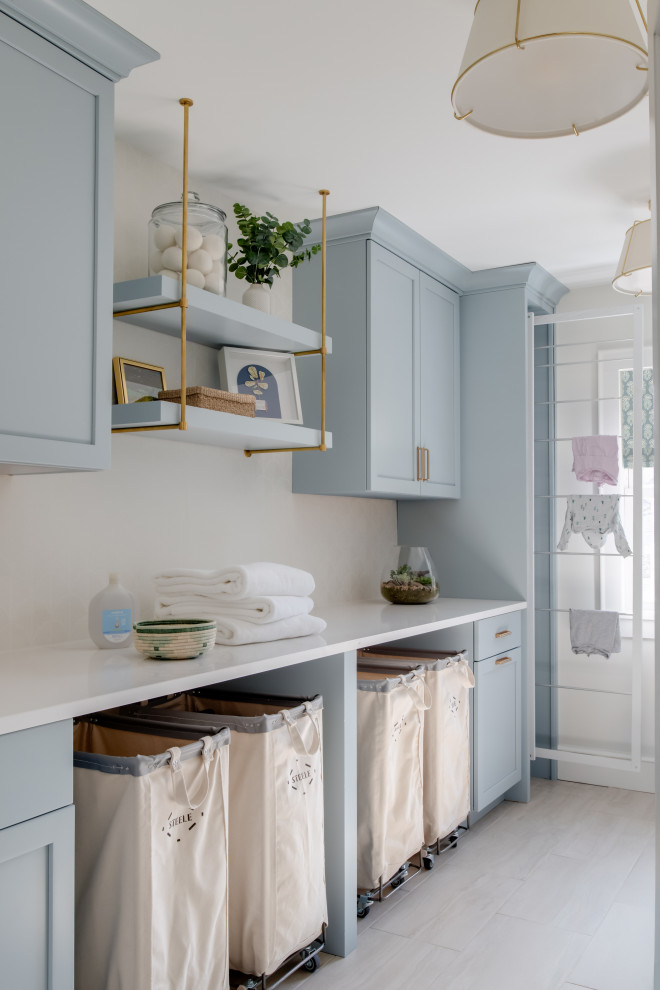 Mid-sized beach style galley ceramic tile and beige floor dedicated laundry room photo in DC Metro with an undermount sink, shaker cabinets, blue cabinets, quartz countertops, white backsplash, mosaic tile backsplash, white walls, a side-by-side washer/dryer and white countertops