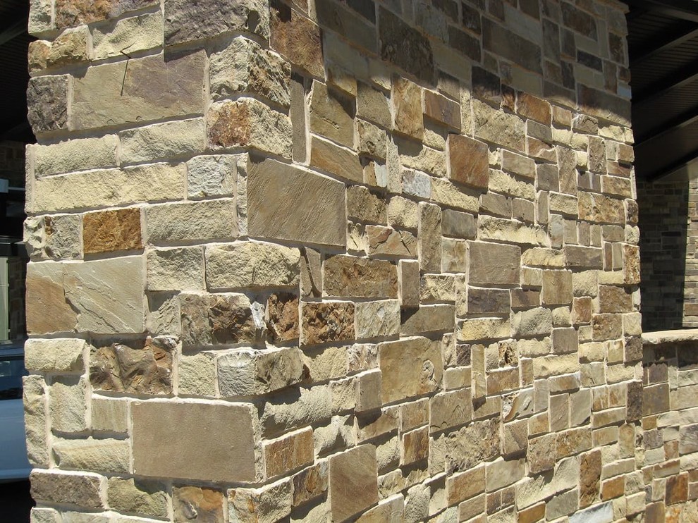 Inspiration for a traditional brown apartment exterior in Other with stone veneer.