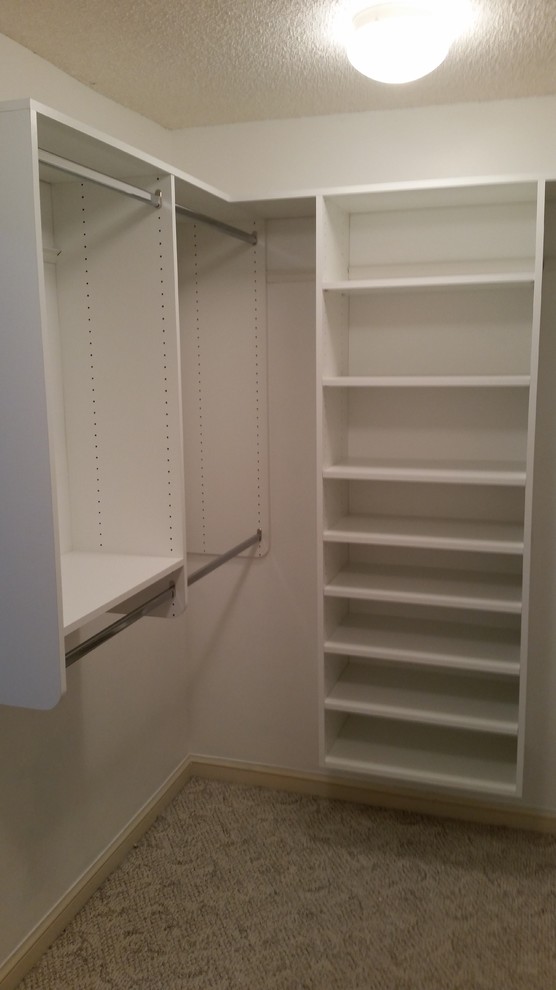 Inspiration for a mid-sized traditional gender-neutral walk-in wardrobe in Jacksonville with open cabinets, white cabinets, carpet and beige floor.