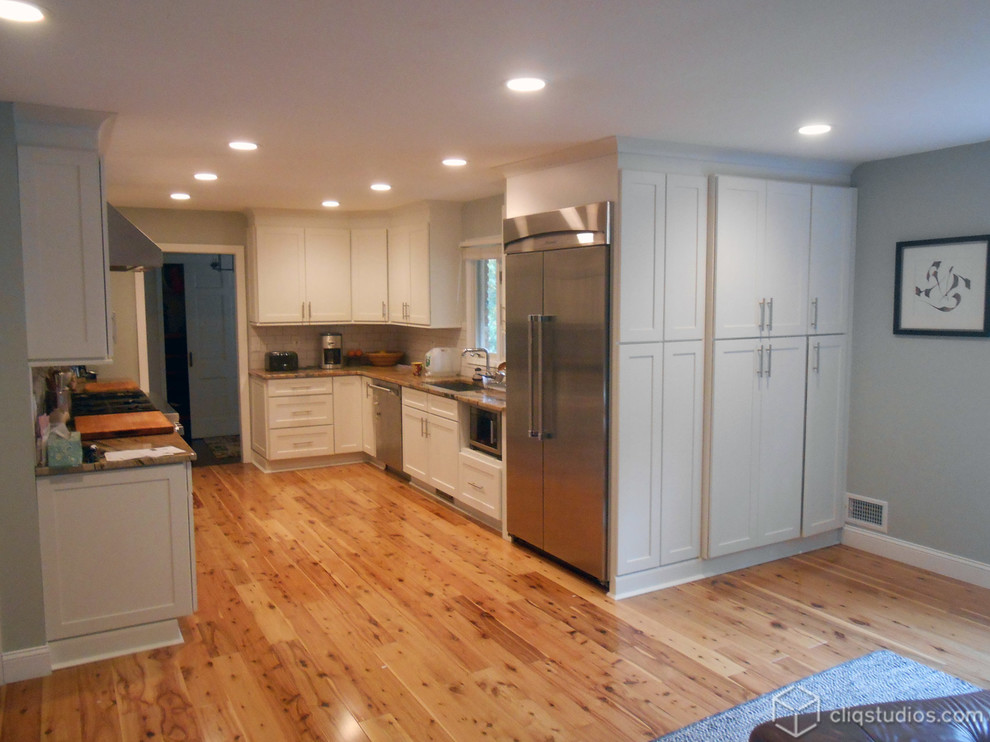 Example of a classic u-shaped eat-in kitchen design in Philadelphia with an integrated sink, shaker cabinets, white cabinets, granite countertops, white backsplash, stainless steel appliances and porcelain backsplash