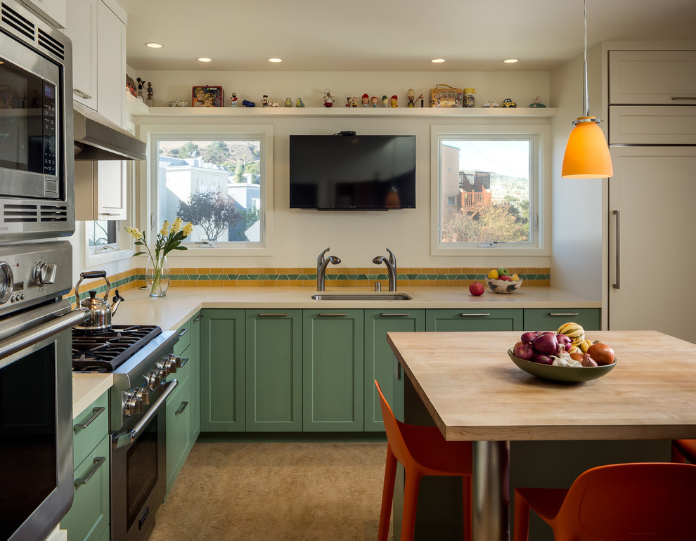 Design ideas for a mid-sized contemporary l-shaped kitchen pantry in San Francisco with an undermount sink, shaker cabinets, green cabinets, quartz benchtops, orange splashback, ceramic splashback, stainless steel appliances, linoleum floors, with island and brown floor.