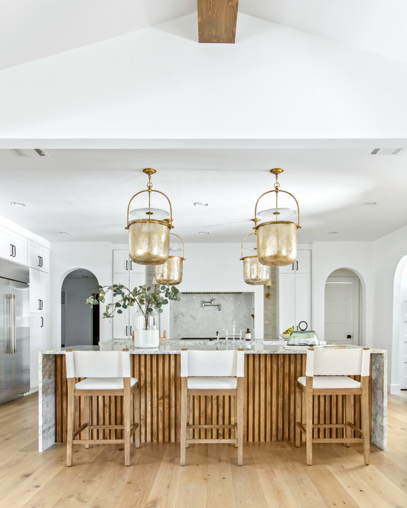 Inspiration for a huge transitional light wood floor and brown floor open concept kitchen remodel in Dallas with shaker cabinets, white cabinets, white backsplash, stainless steel appliances, two islands, white countertops, a farmhouse sink, marble countertops and marble backsplash