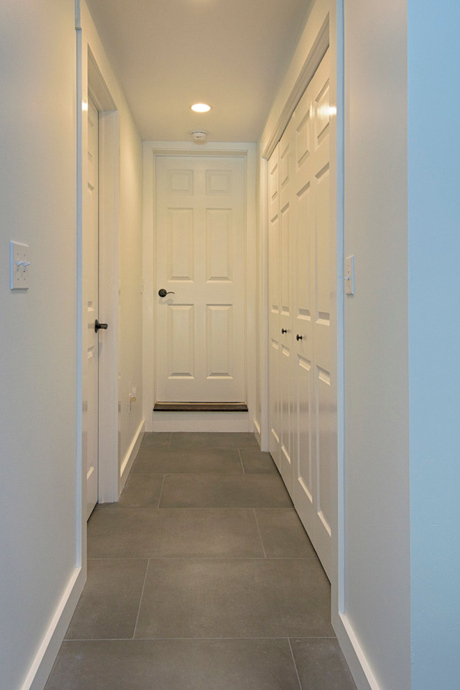 Large country hallway in New York with grey walls and slate floors.