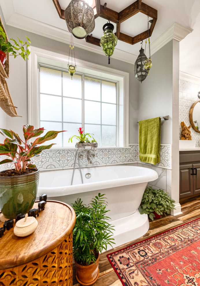 Mid-sized eclectic master multicolored tile and porcelain tile porcelain tile and brown floor freestanding bathtub photo with raised-panel cabinets, black cabinets, a two-piece toilet, gray walls, a vessel sink, quartzite countertops and white countertops