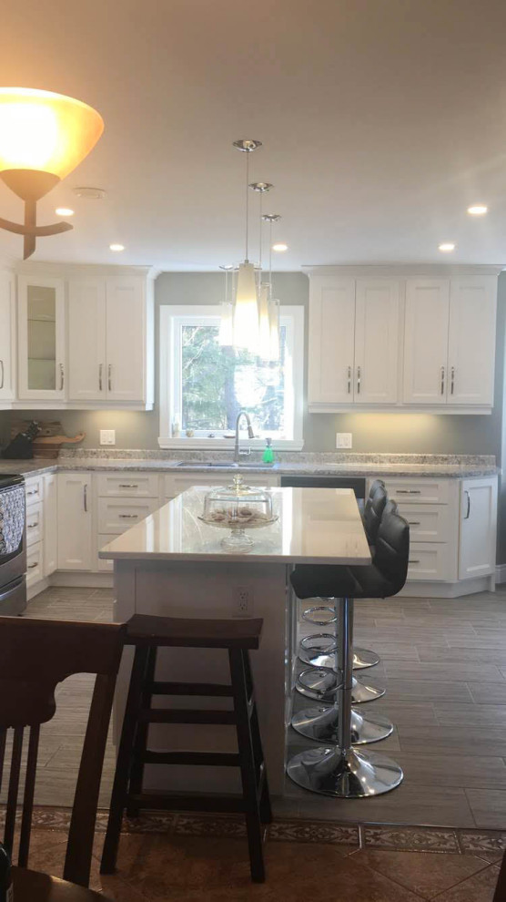 Mid-sized transitional u-shaped porcelain tile and gray floor eat-in kitchen photo with an undermount sink, recessed-panel cabinets, white cabinets, quartz countertops, stainless steel appliances, an island and white countertops