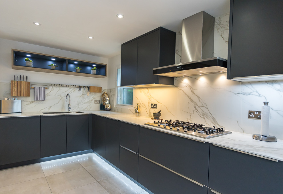 Design ideas for a large modern l-shaped open plan kitchen in Surrey with an integrated sink, flat-panel cabinets, grey cabinets, solid surface benchtops, white splashback, slate splashback, stainless steel appliances, porcelain floors, with island and grey floor.