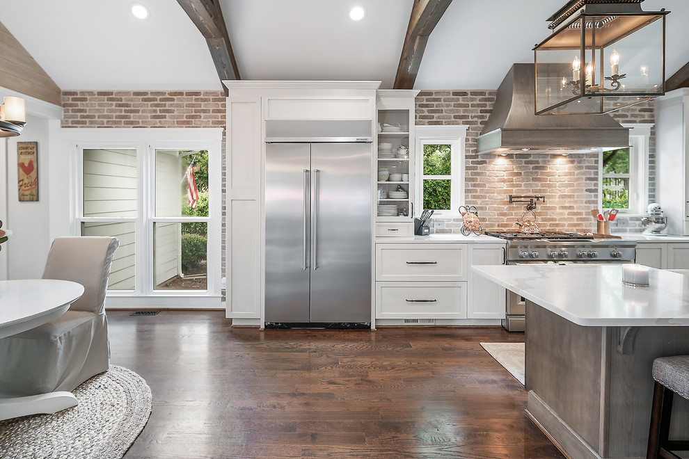 Inspiration for a large transitional galley kitchen in Charlotte with a farmhouse sink, quartz benchtops, stainless steel appliances, medium hardwood floors and with island.