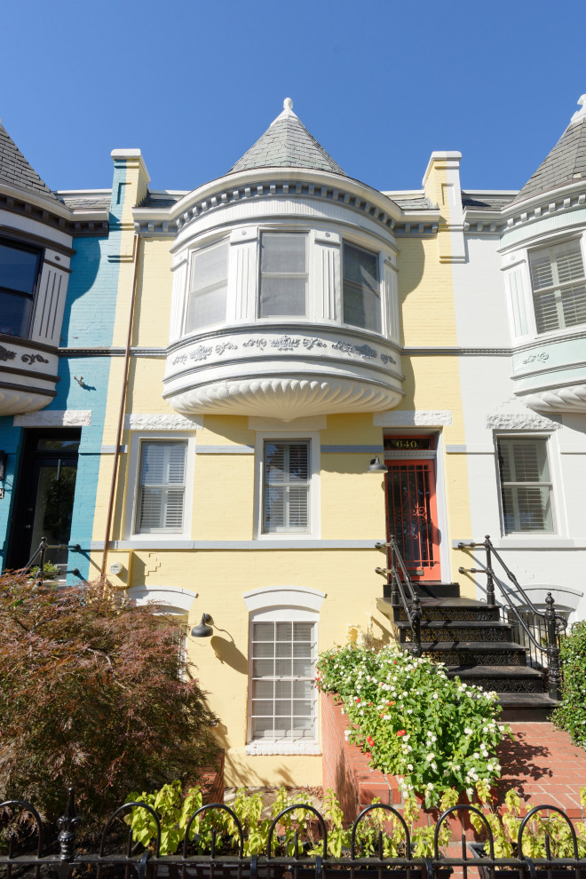 Immagine della facciata di una casa a schiera gialla classica