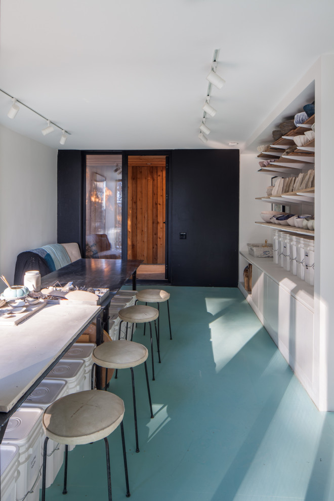 Idéer för ett modernt hemmastudio, med vita väggar, betonggolv och blått golv