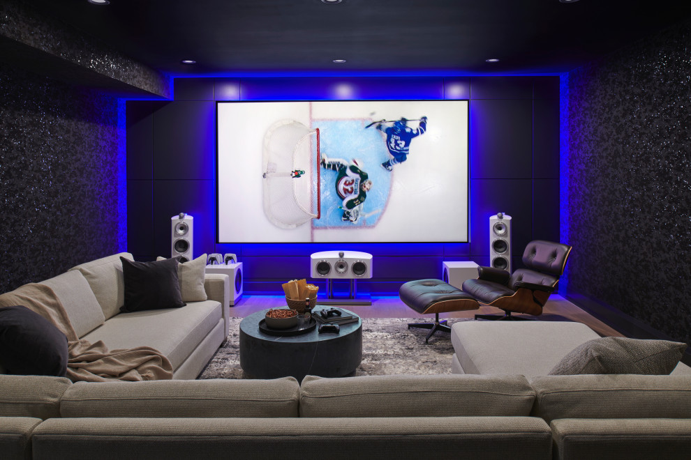 Inspiration for a large traditional home cinema in Toronto with black walls, a projector screen, brown floors and medium hardwood flooring.
