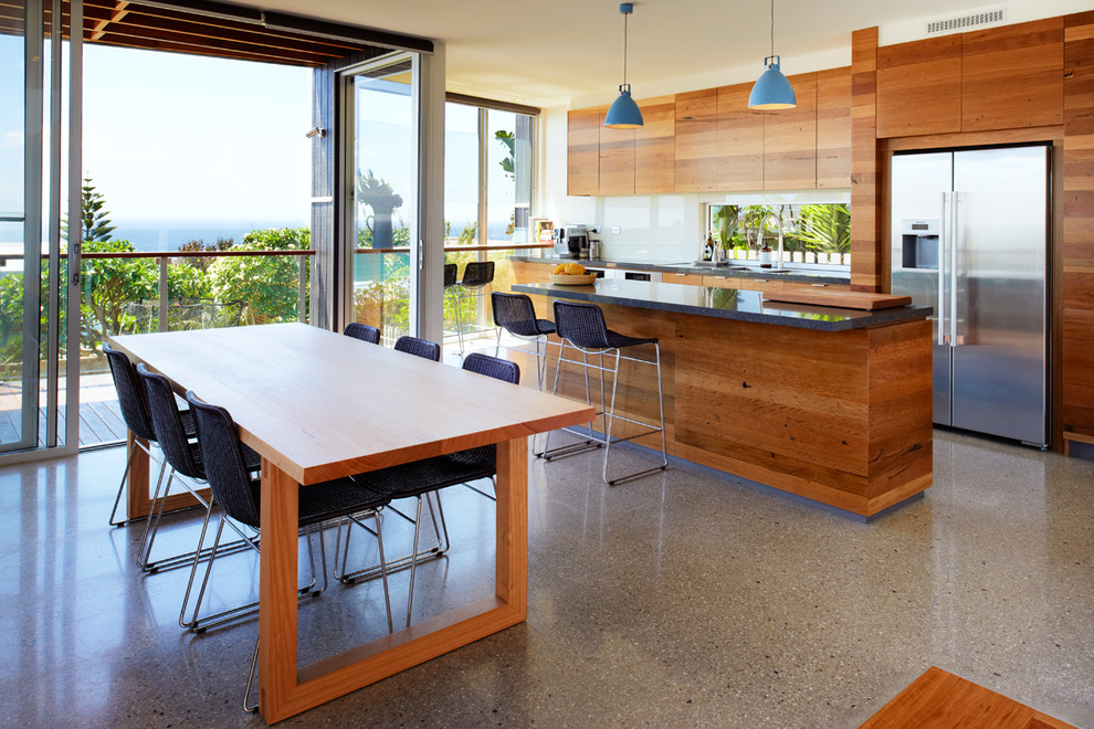 Inspiration for a mid-sized contemporary galley eat-in kitchen in Sydney with flat-panel cabinets, medium wood cabinets, quartz benchtops, white splashback, glass sheet splashback, stainless steel appliances, concrete floors and with island.