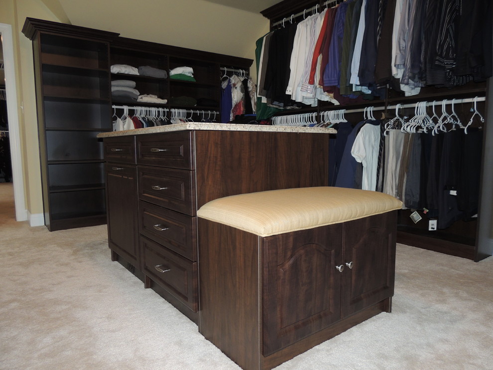 Design ideas for a large traditional gender-neutral walk-in wardrobe in Philadelphia with raised-panel cabinets, dark wood cabinets and carpet.