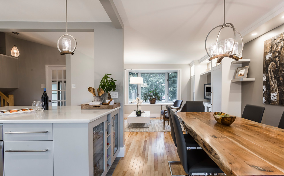 Inspiration for a mid-sized transitional kitchen/dining combo in Other with grey walls, light hardwood floors, a hanging fireplace and beige floor.